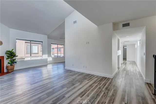 a living room with stainless steel appliances wooden floor and a large window
