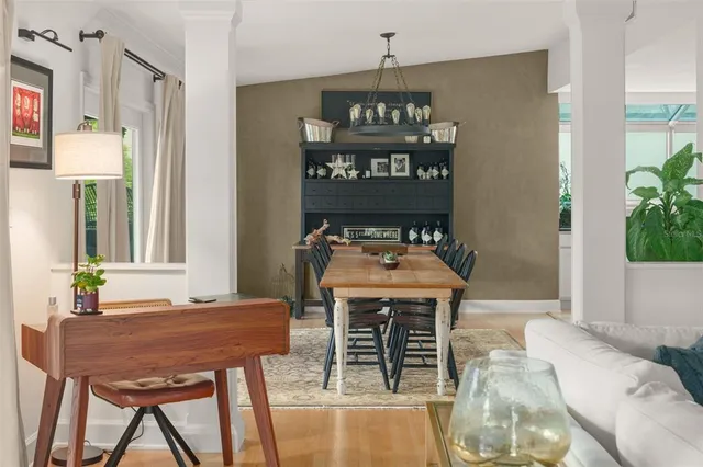 a view of a dining room with furniture a kitchen and chandelier
