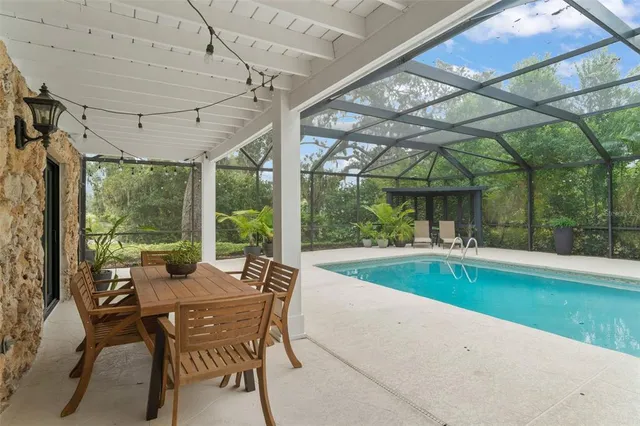 a view of a swimming pool with a patio and a yard