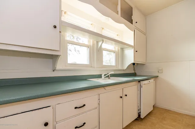 a bathroom with a granite countertop sink and a large mirror