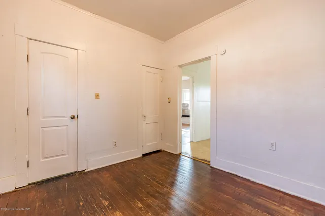 a view of an empty room with wooden floor