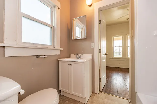 a bathroom with a sink a toilet and a mirror