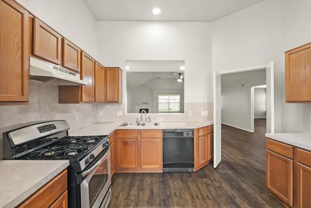 a kitchen with stainless steel appliances granite countertop a stove and a sink