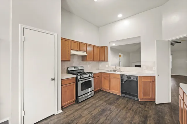 a kitchen with stainless steel appliances granite countertop a stove and a sink