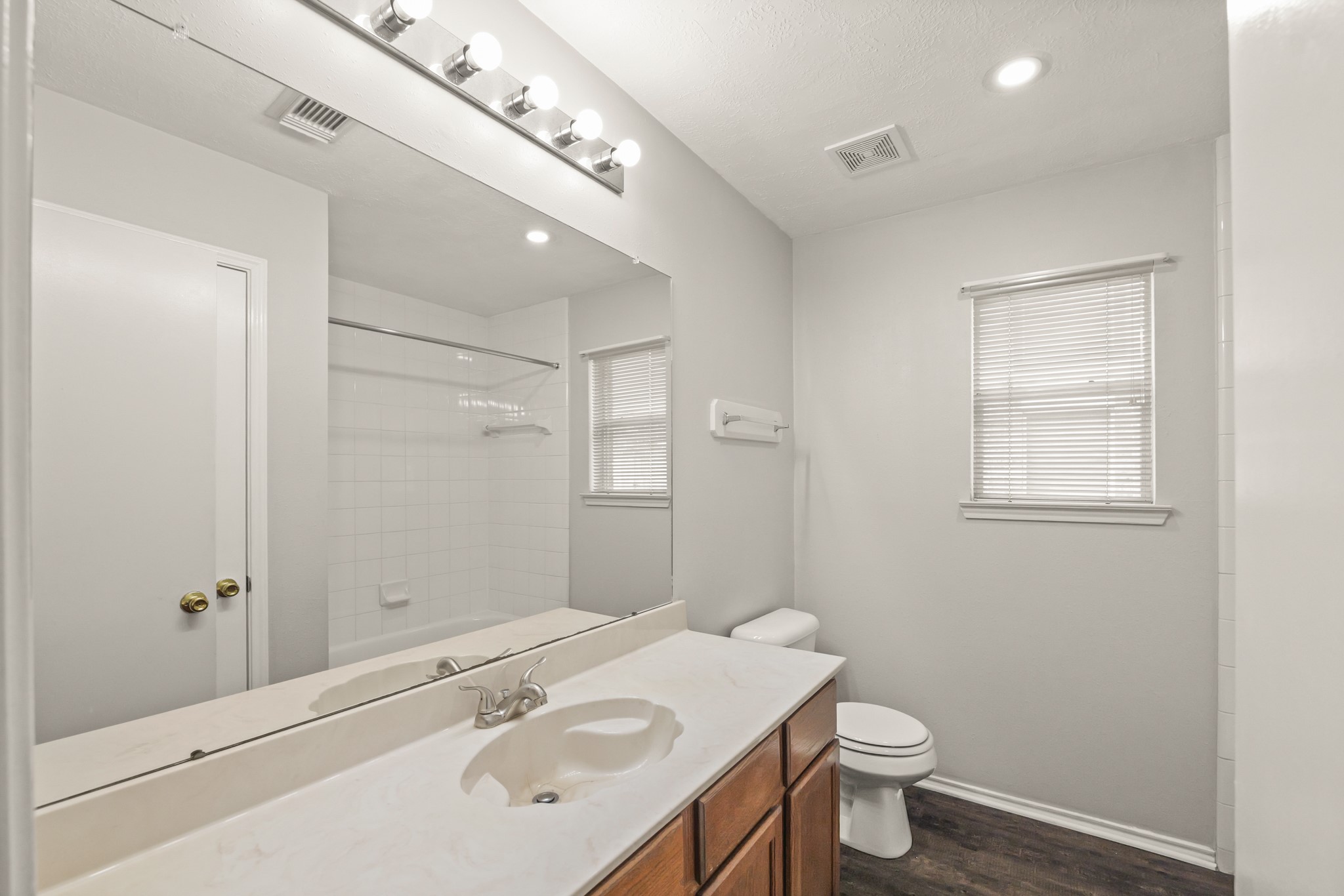 3651 Woodlace Drive Humble, TX 77396 - Photo 20 of 38 a bathroom with a sink vanity granite toilet and a mirror