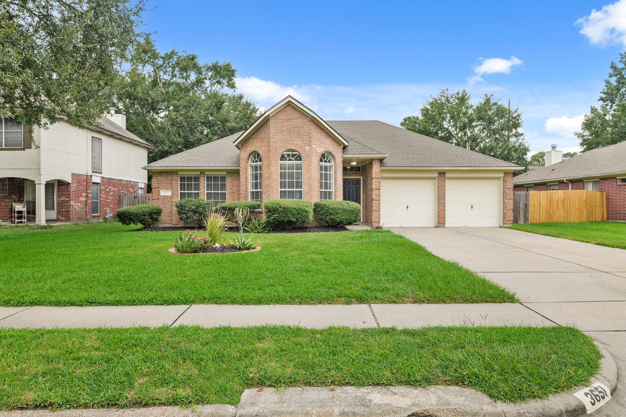 3651 Woodlace Drive Humble, TX 77396 - Photo 3 of 38 a front view of a house with a garden and yard