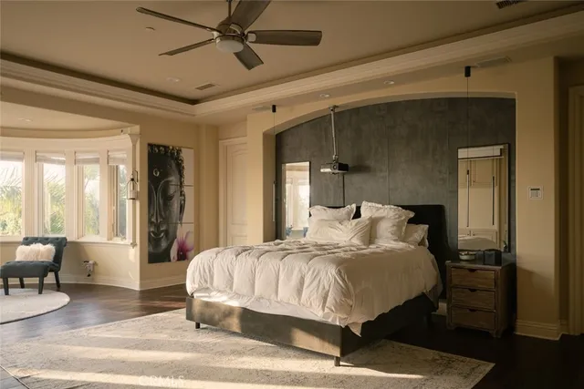 a bedroom with a bed and large windows