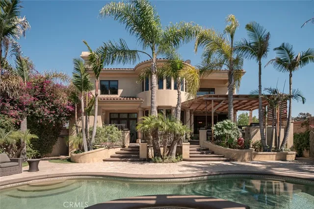 a view of house with small yard and palm trees
