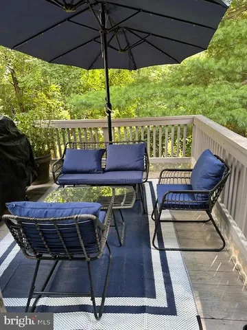 a patio with wooden floor a yard a table and chairs