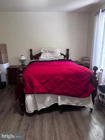a bedroom with a bed and a wooden floor