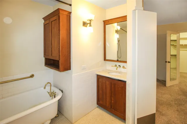 a bathroom with a tub sink and mirror
