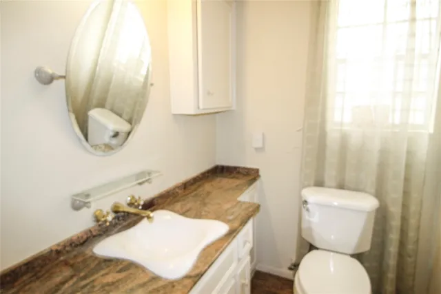 a bathroom with a toilet sink and mirror