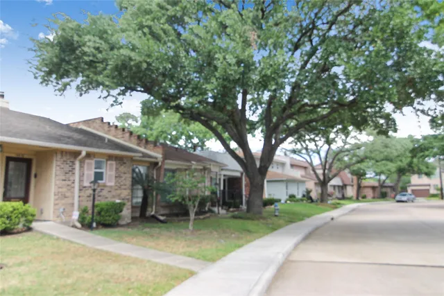 a view of a house with a tree in front of it