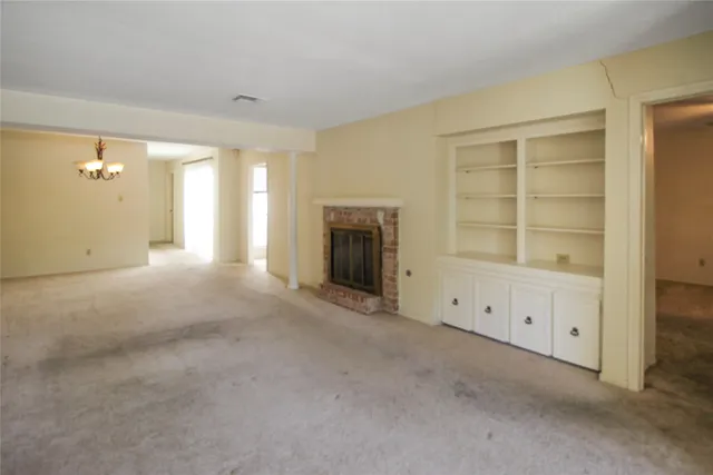 an empty room with windows and cabinet