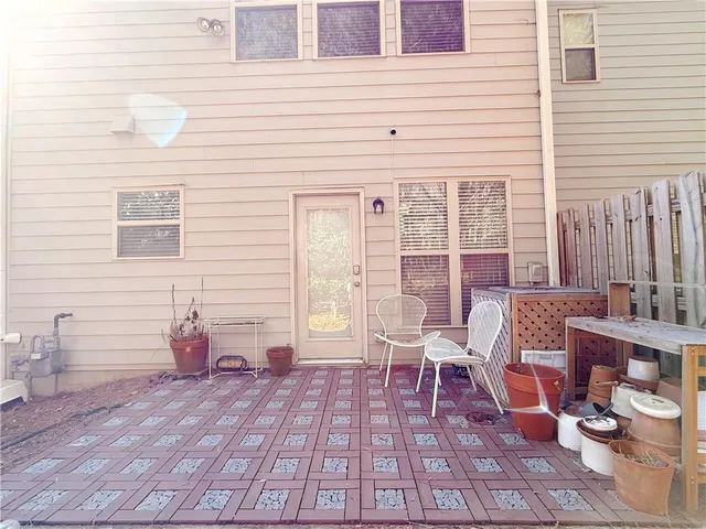 a view of a patio with chairs and potted plants
