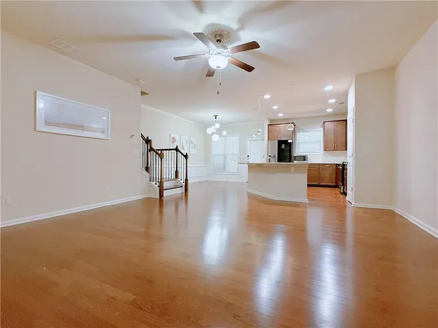 a view of a kitchen with a kitchen island wooden floor appliances and a chandelier
