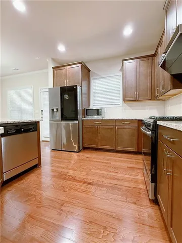 a large kitchen with stainless steel appliances granite countertop a stove a sink and a refrigerator