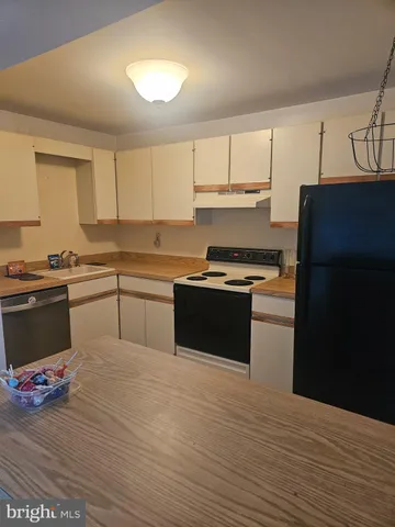 a kitchen with a refrigerator and a stove top oven