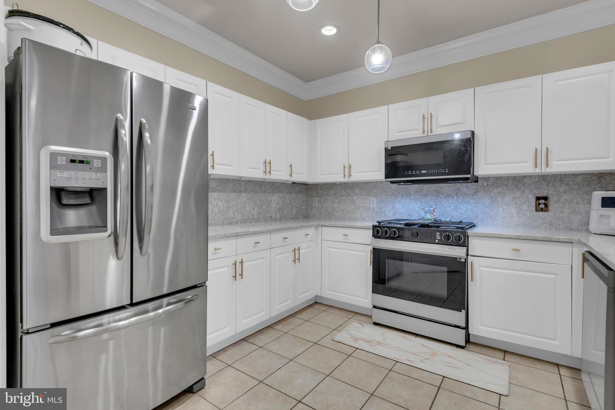 7 Booth Street, Unit 302 Gaithersburg, MD 20878 - Photo 15 of 63 a kitchen with stainless steel appliances granite countertop a refrigerator stove a sink and a microwave