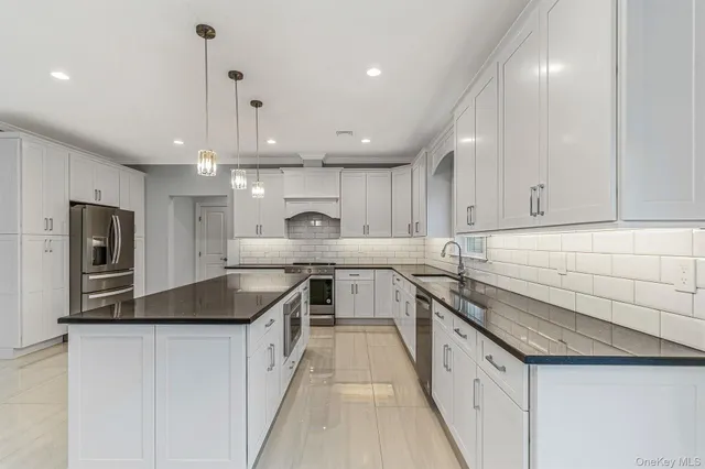 a kitchen with stainless steel appliances granite countertop a sink a stove and a refrigerator