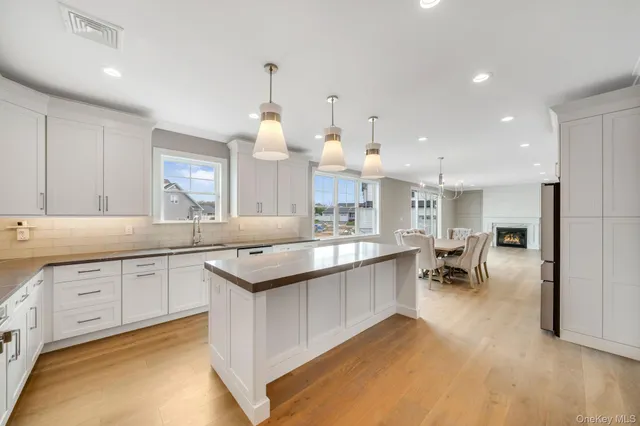 a large kitchen with kitchen island a sink and a stove in it