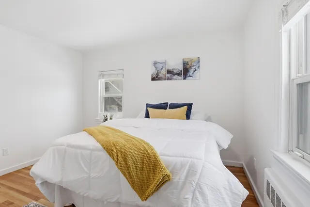 a bedroom with a bed and painting on the wall