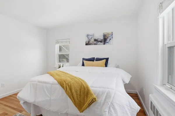 a bedroom with a bed and painting on the wall