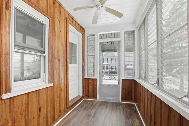 a view of hallway with wooden floor and fan