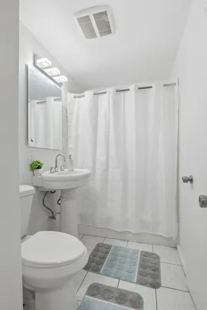 a bathroom with a sink a toilet and a shower