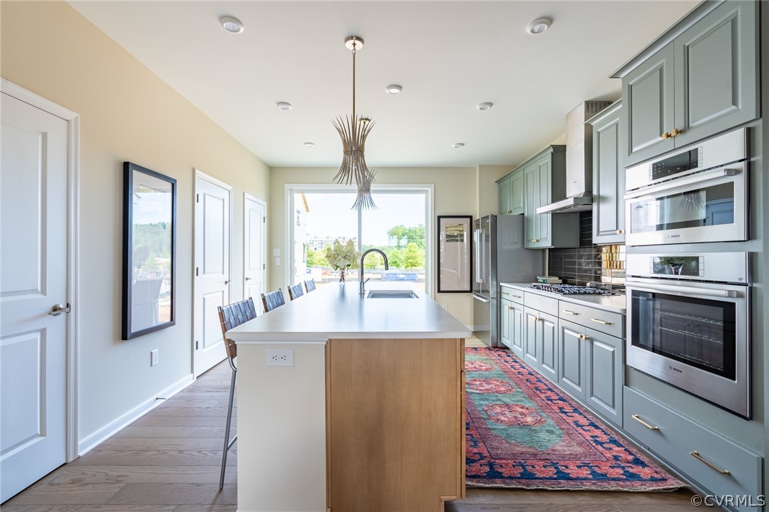 a large kitchen with kitchen island a large window and stainless steel appliances