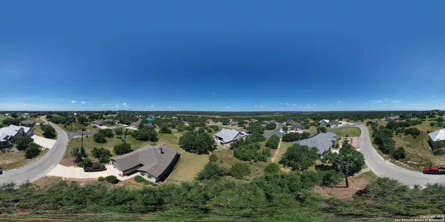 an aerial view of a residential house with a yard