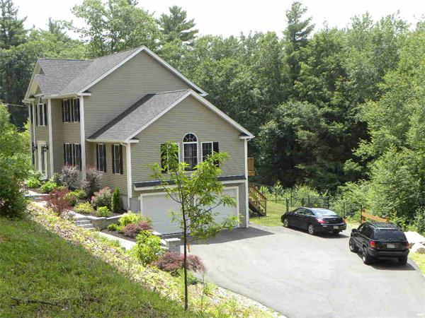 52 Baker Pond Road Charlton, MA 01507 - Photo 1 of 30 a front view of a house with a yard and fountain