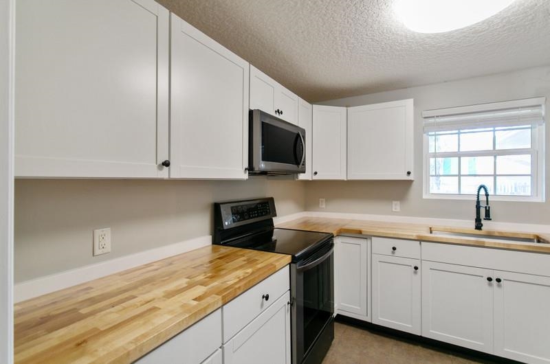 347 Lobelia Road St. Augustine, FL 32086 - Photo 9 of 40 a kitchen with white cabinets sink and window