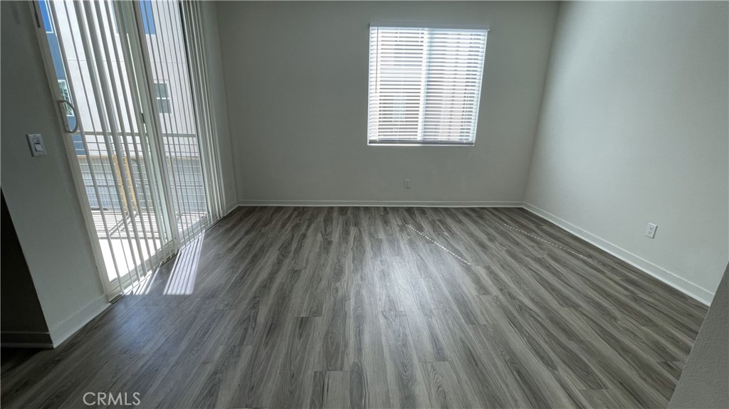 115 Citysquare Irvine, CA 92614 - Photo 12 of 30 an empty room with wooden floor and windows