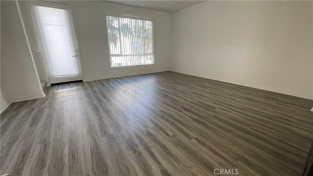 115 Citysquare Irvine, CA 92614 - Photo 13 of 30 an empty room with wooden floor and windows