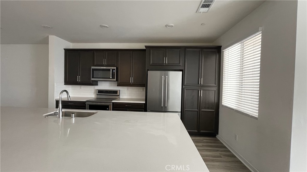 115 Citysquare Irvine, CA 92614 - Photo 6 of 30 a kitchen with a refrigerator and a sink