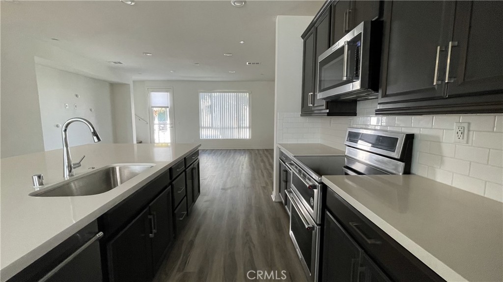 115 Citysquare Irvine, CA 92614 - Photo 8 of 30 a kitchen with stainless steel appliances granite countertop a sink a stove microwave and cabinets