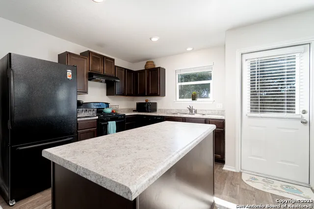 a kitchen with stainless steel appliances granite countertop a refrigerator and a sink