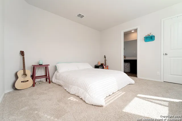 a spacious bedroom with a bed and a window