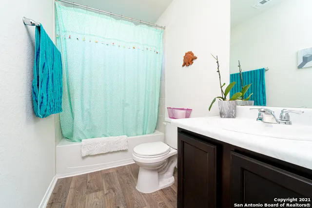 a bathroom with a granite countertop sink a toilet and shower