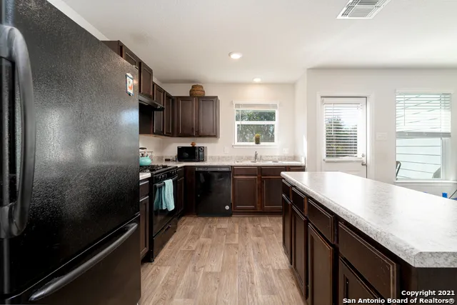 a kitchen with granite countertop a sink stove and refrigerator