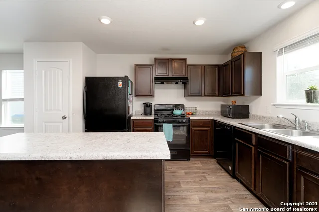 a kitchen with stainless steel appliances a refrigerator sink stove microwave and cabinets