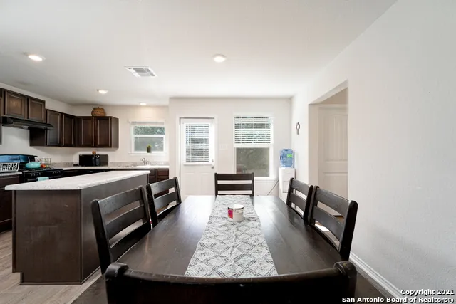 a view of a dining room with furniture a rug and wooden floor