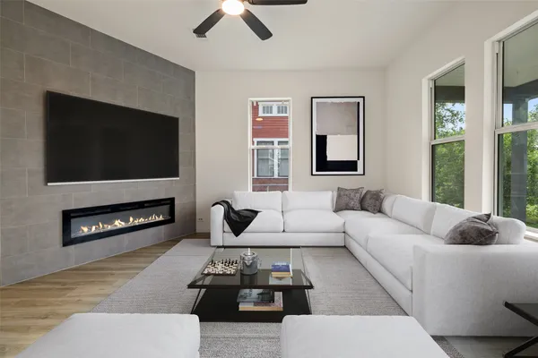 a living room with furniture a flat screen tv and a fireplace