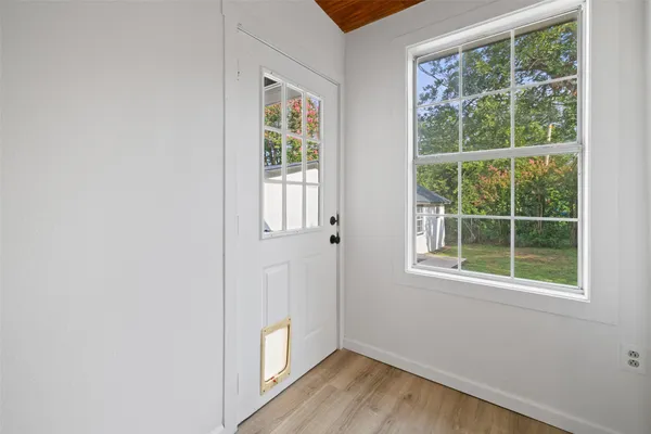 an empty room with wooden floor and windows
