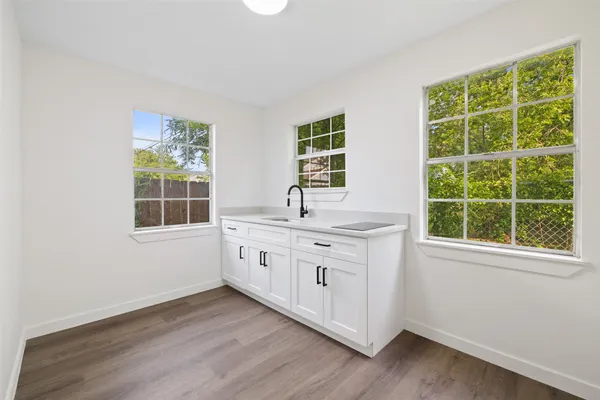 a kitchen with wooden floors and windows