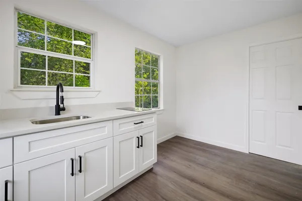 a kitchen with a sink and wooden floor