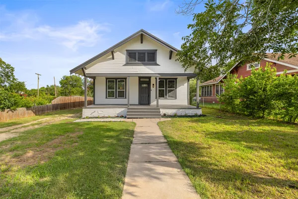 a front view of a house with yard and green space