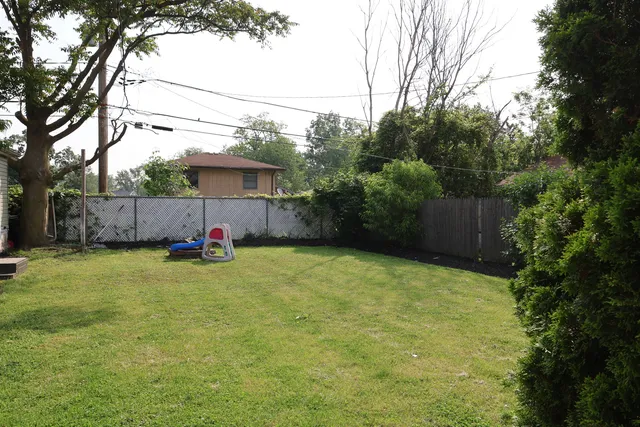 a view of a backyard with table and chairs and wooden fence