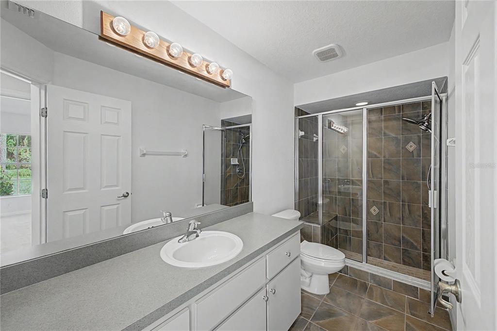 15031 Surrey Bend Spring Hill, FL 34609 - Photo 31 of 77 a bathroom with a toilet a sink and shower